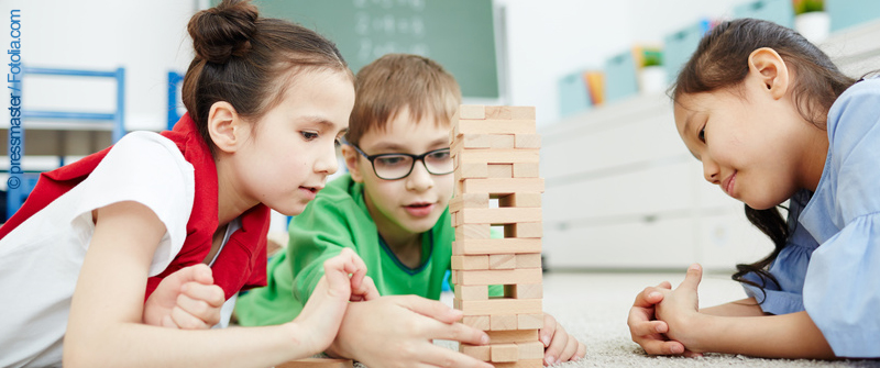 Schulbezogene Sozialarbeit an der Reinhardswald-Grundschule, Berlin Kreuzberg, drei Kinder beim Wackelturm-Spiel Schulbezogene Sozialarbeit an der Reinhardswald-Grundschule, Berlin Kreuzberg, drei Kinder beim Wackelturm-Spiel